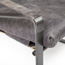 Silla decorativa de cuero negro con estructura de metal