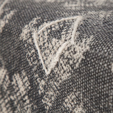 Otomana cubierta de tela estampada con patas de madera