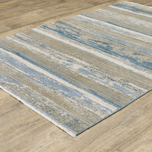 4' X 6' Ivory Beige Grey Blue And Tan Abstract Power Loom Stain Resistant Area Rug With Fringe
