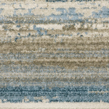 4' X 6' Ivory Beige Grey Blue And Tan Abstract Power Loom Stain Resistant Area Rug With Fringe