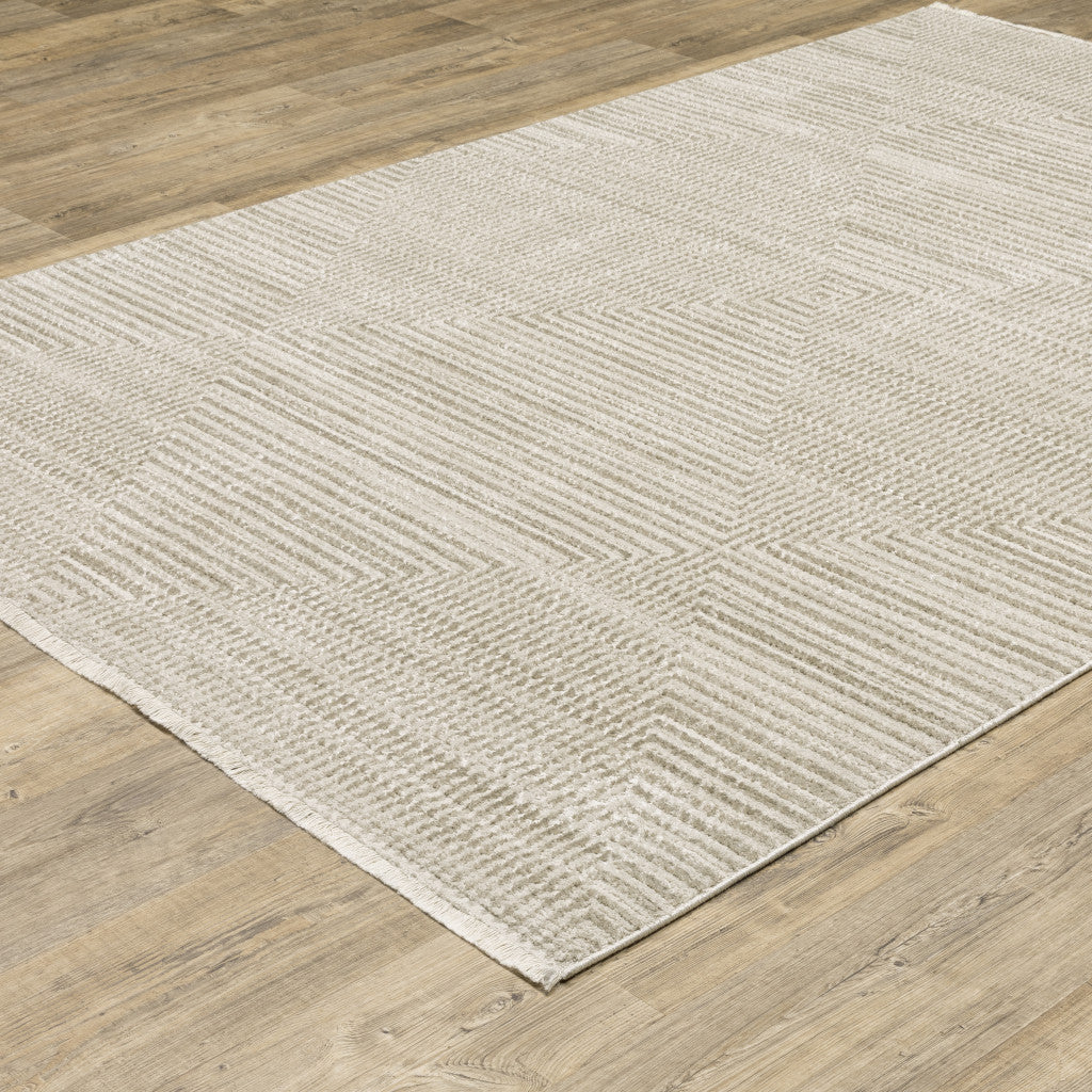 6' X 9' Ivory Beige Taupe And Tan Geometric Power Loom Stain Resistant Area Rug With Fringe